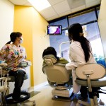 Dental team consulting with child patient in treatment room