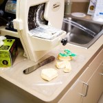 Dental model trimmer on counter with trimmed stone models and tools